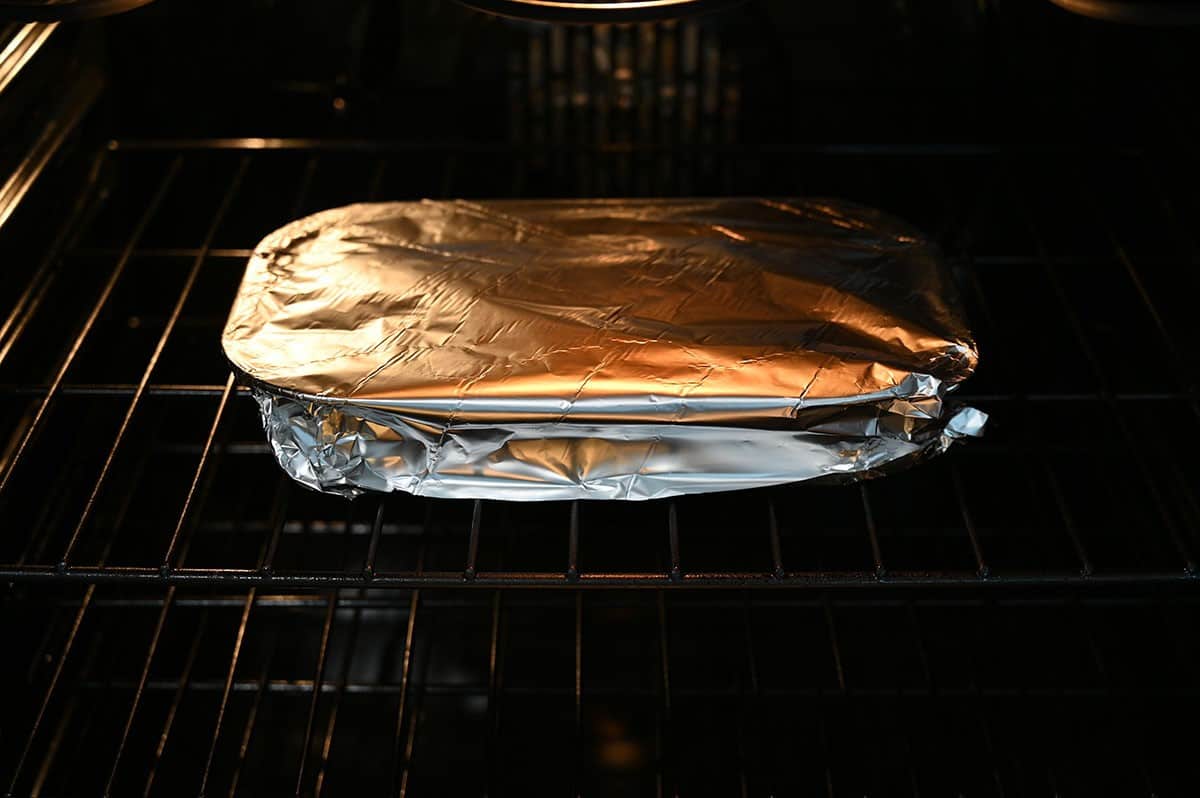 Image of Costco Four Cheese and Spinach Manicotti cooking in the oven, covered with foil. 