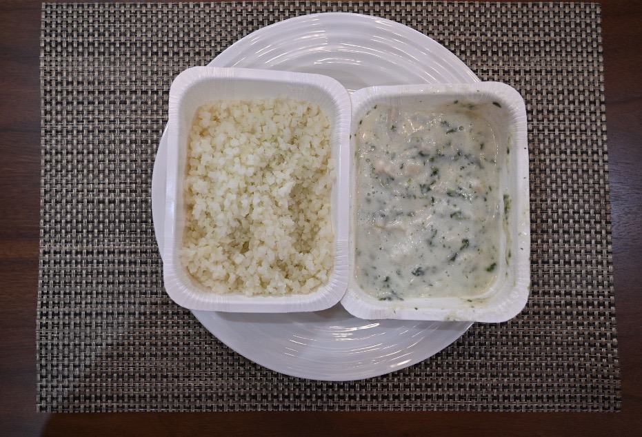 Trays of riced cauliflower and chicken Florentine sauce