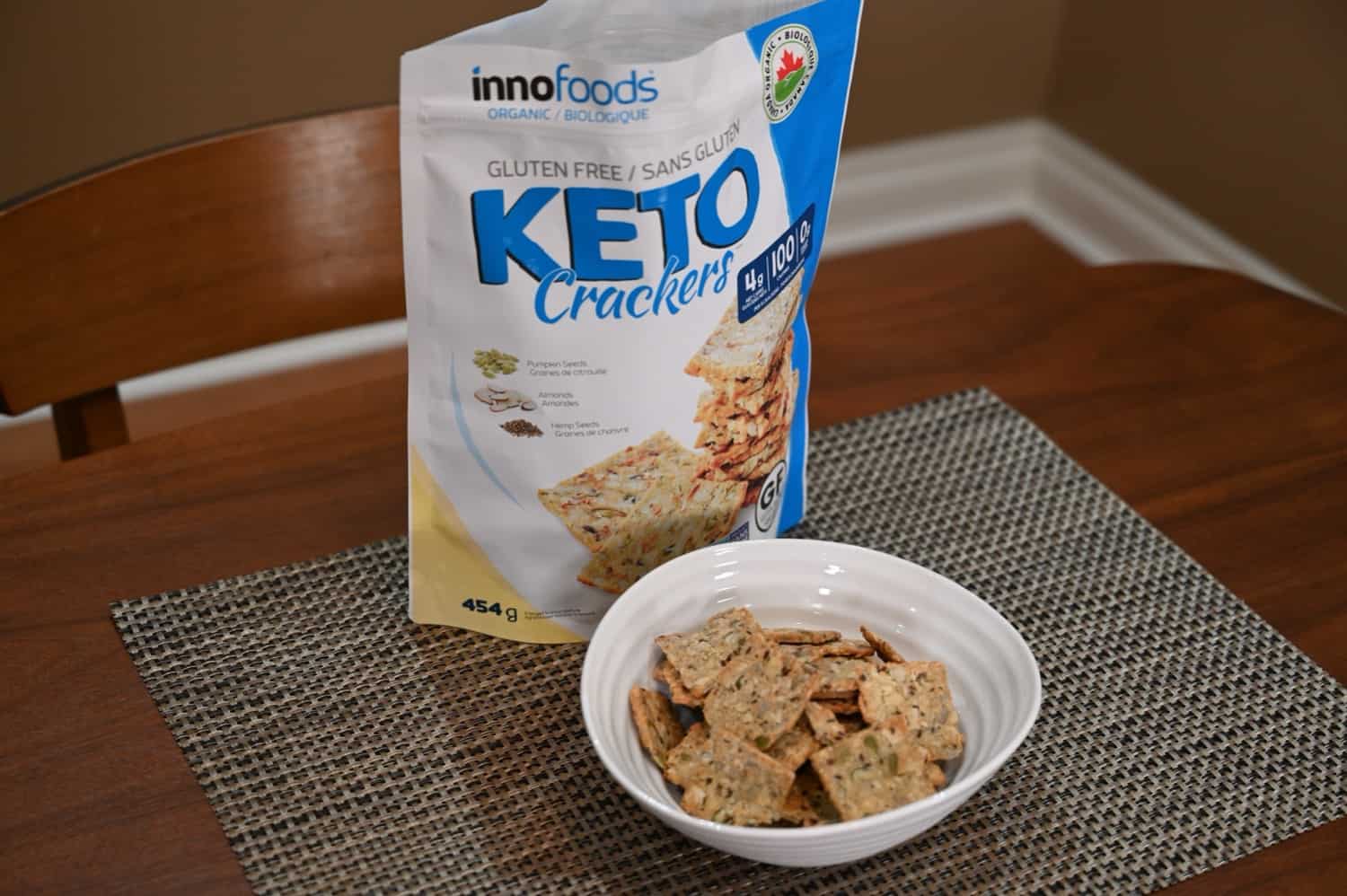A bowl of the innofoods Keto Crackers in front of the bag.
