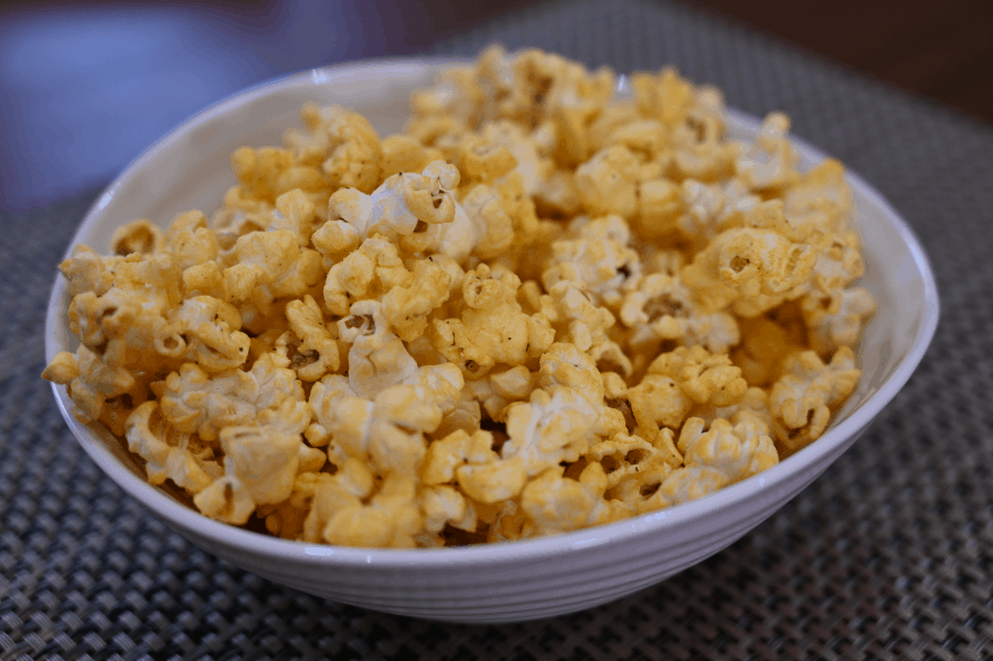 Close-up photo of a bowl of the French Cancan cheddar & green onion popcorn.