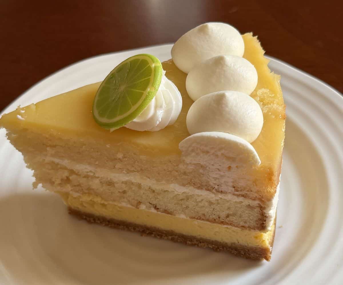 Closeup image of one slice of key lime cake served on a white plate.
