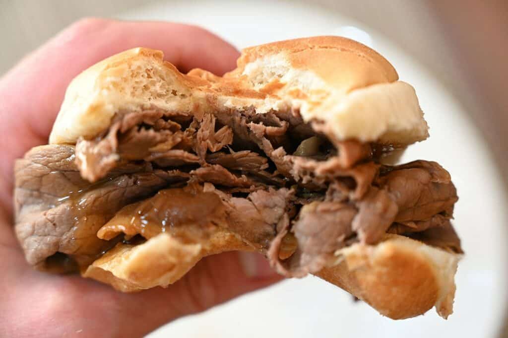 Costco Stoney Creek Shaved Beef Au Jus bite out of sandwich with the shaved beef.