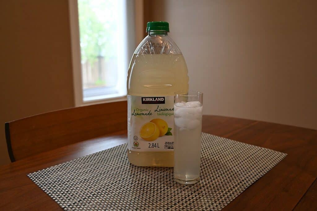 Costco Kirkland Signature Lemonade poured in a glass beside the bottle