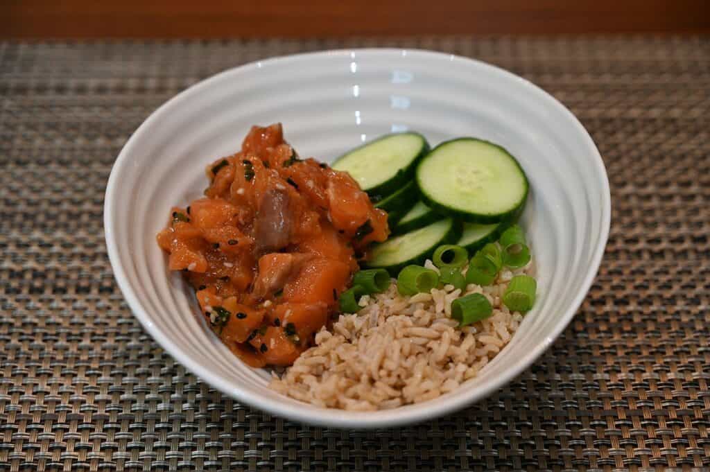 Costco Dom Reserve Singles Steelhead Salmon Poke in a bowl with rice, green onion and cucumber. 