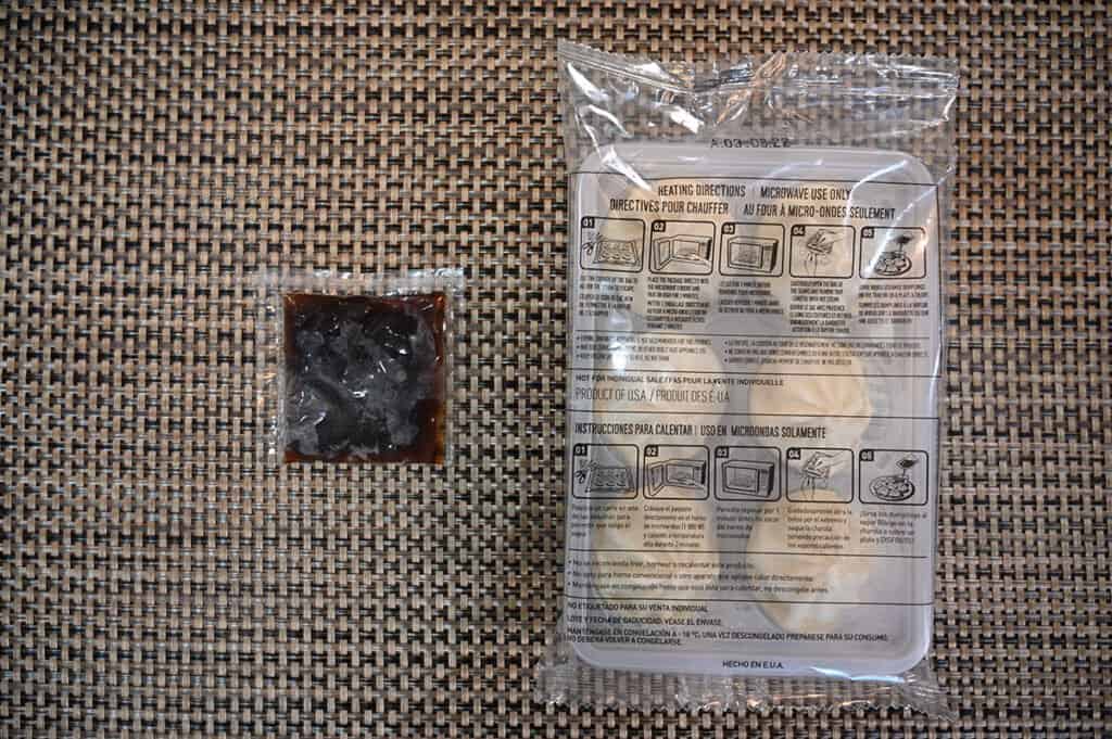 A tray of the steamed dumplings and a packet of the sauce.