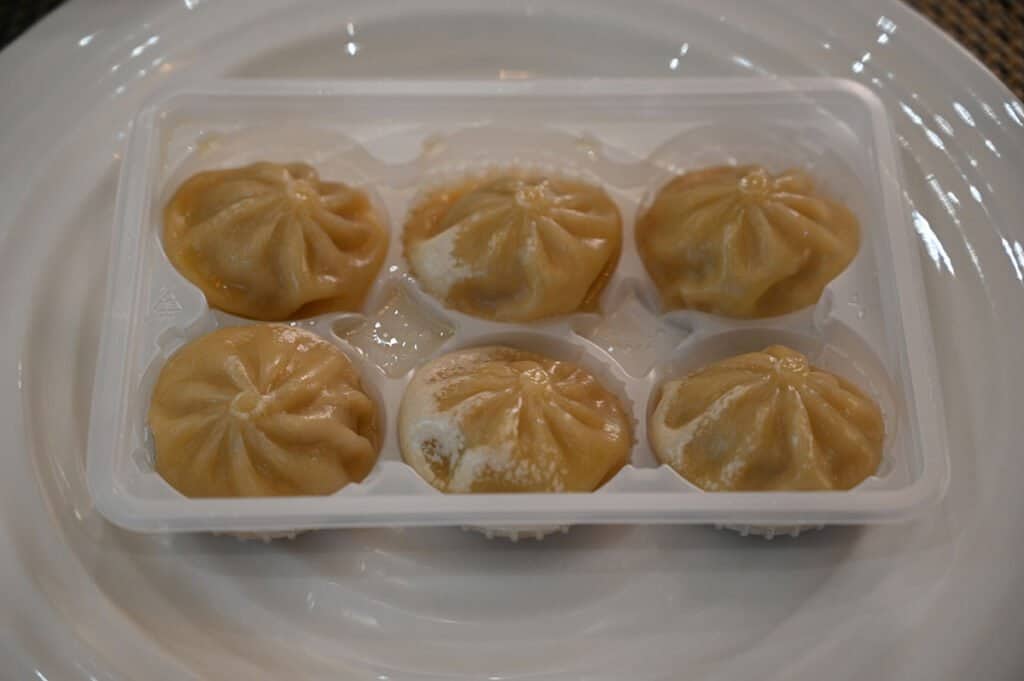 A close-up of a tray of six of the steamed dumplings.