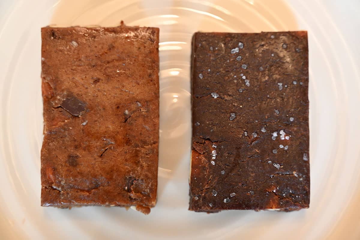 A close-up of two unwrapped RXBARs - one of each kind in the box. Coconut chocolate on left and chocolate sea salt on right. Unwrapped on a white plate.