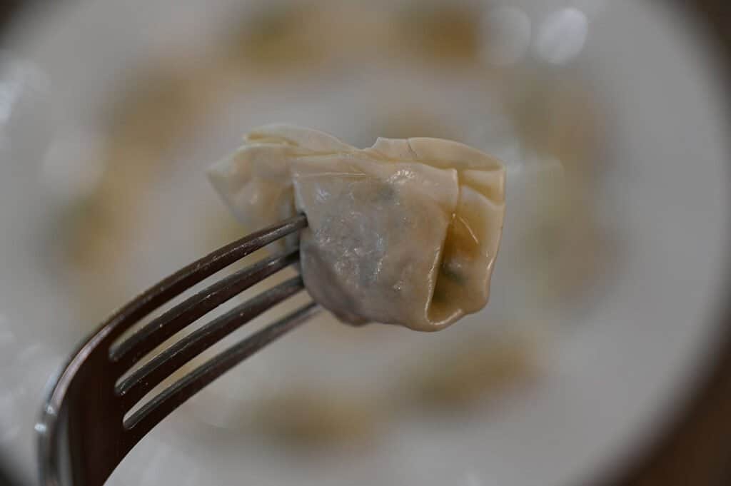 A close-up of a mini wonton on a fork.