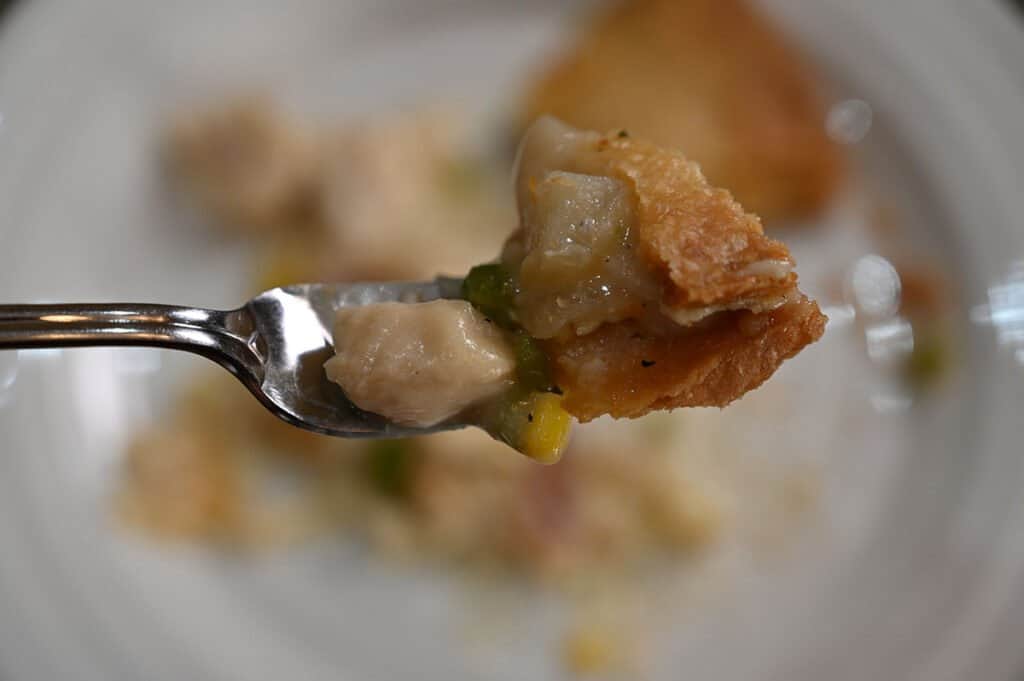 A close-up of a bit of chicken pot pie on a fork.