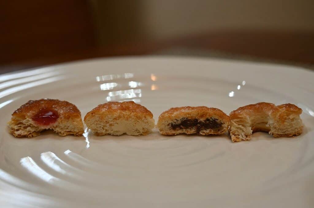 Costco Matilde Vicenzi Millefoglie D'Italia Puff Pastries- raspberry, cream, chocolate and butter from left to right with a bite taken out of each. 