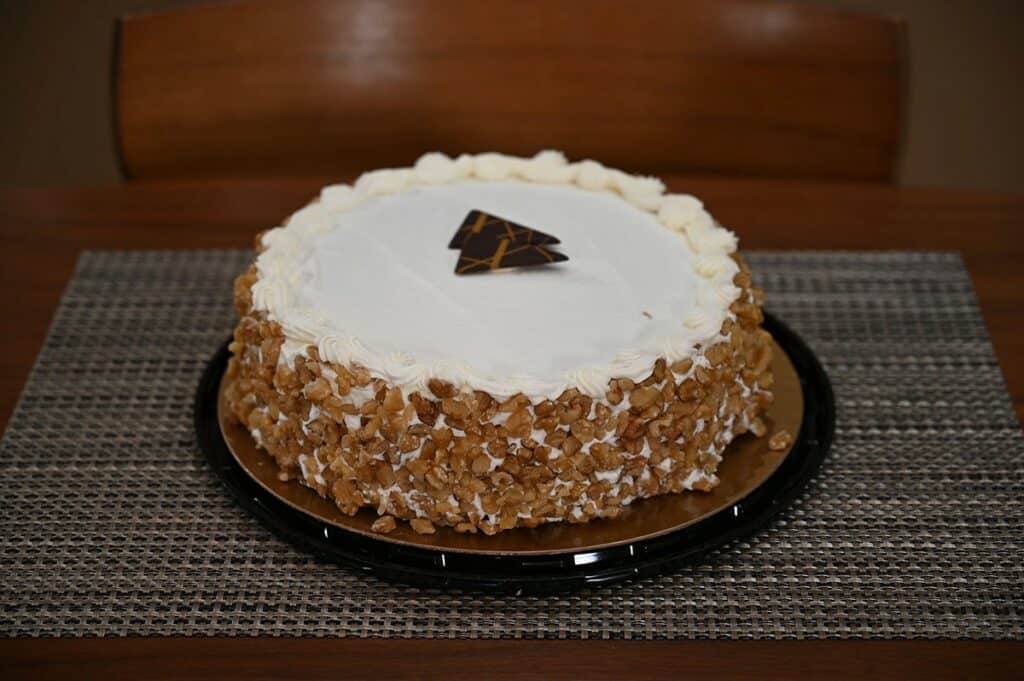 Costco Kirkland Signature Carrot Cheesecake image of whole carrot cake with lid off sitting on a placemat on table