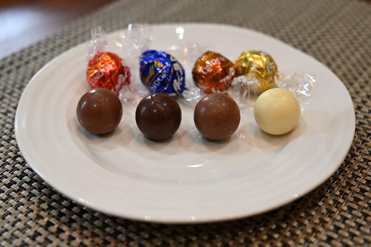 Costco Lindt Lindor Assorted Chocolates unwrapped on a plate, left to right, milk chocolate, dark chocolate, hazelnut, white chocolate