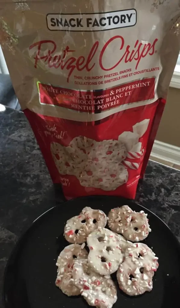 Photo of the Costco Snack Factory White Chocolate & Peppermint Pretzel Crisps on a plate beside the bag.