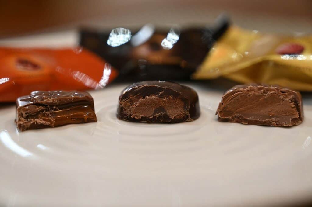 Costco Godiva Masterpieces Chocolates image of three different kinds of chocolates unwrapped and on a plate, caramel milk chocolate, dark chocolate ganache and hazelnut. 