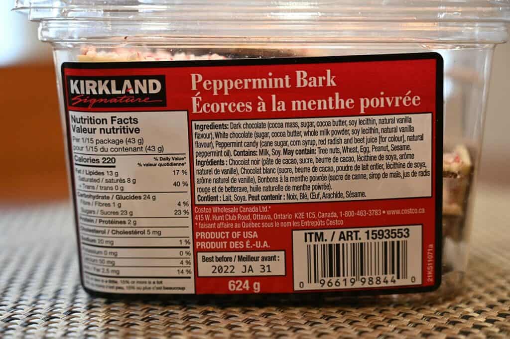 Closeup image of the Costco Kirkland Signature Peppermint Bark container with ingredients, nutrition facts and best before date 