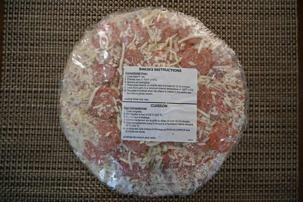 Image of a single Costco Kirkland Signature Pepperoni Pizza with packaging still on including baking instructions