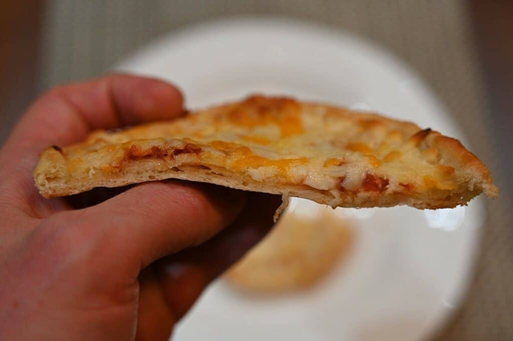 Side closeup image of the Sabatasso's Four cheese pizza cooked and with a bite taken out of it