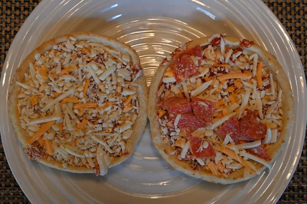 Image of the Costco Sabatasso's Pizza Singles, on a plate, four cheese and pepperoni unwrapped and prior to baking them 