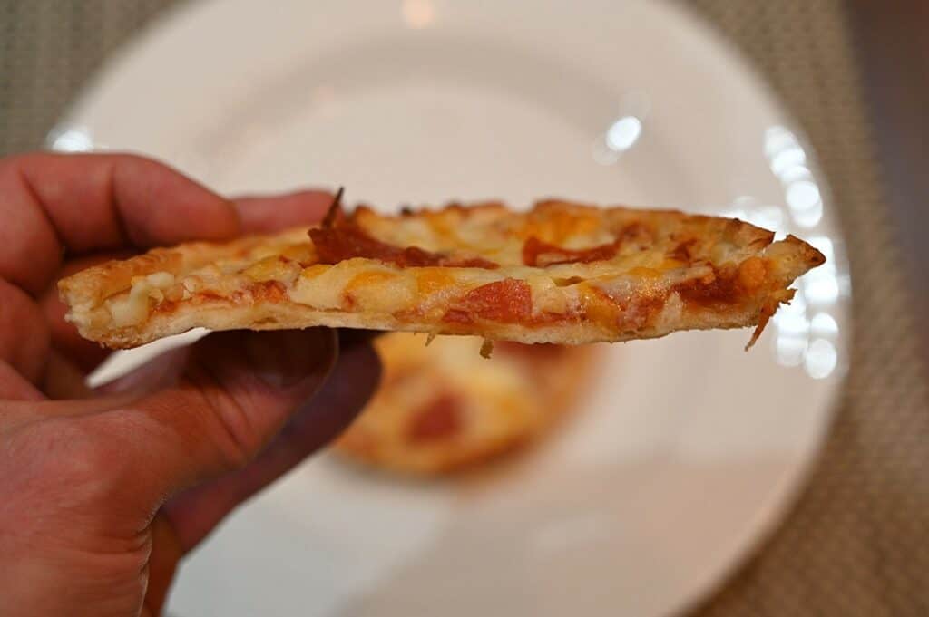 Side closeup image of the Sabatasso's Pepperoni Pizza cooked and with a bite taken out of it