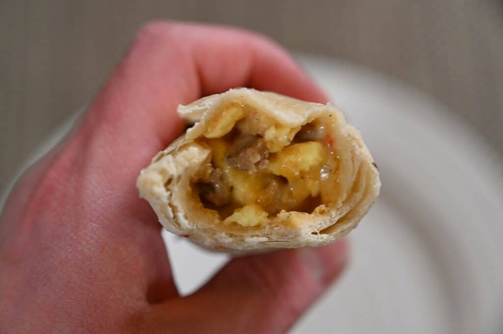 A photo of the Costco El Monterey Breakfast Wraps with a bite taken out of it showing the inside. 