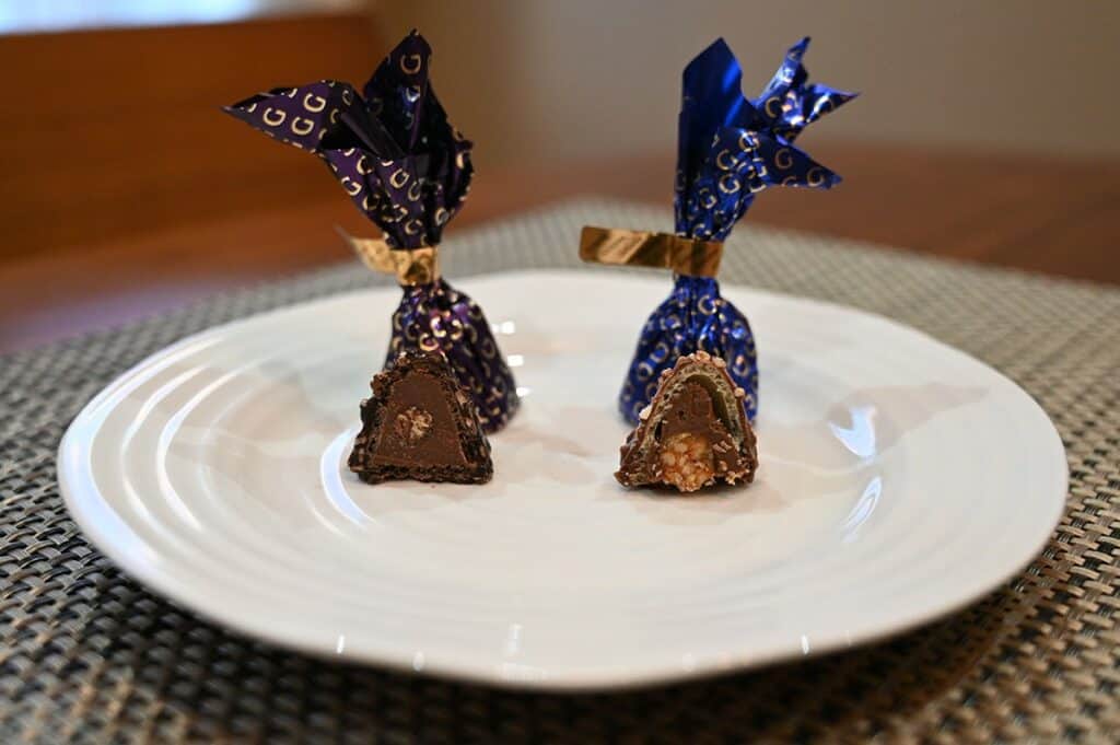 Image of the Costco Godiva Chocolate Domes, both flavors, dark chocolate and milk chocolate unwrapped sitting on a plate with a bite taken out of each so you can see the middle. 
