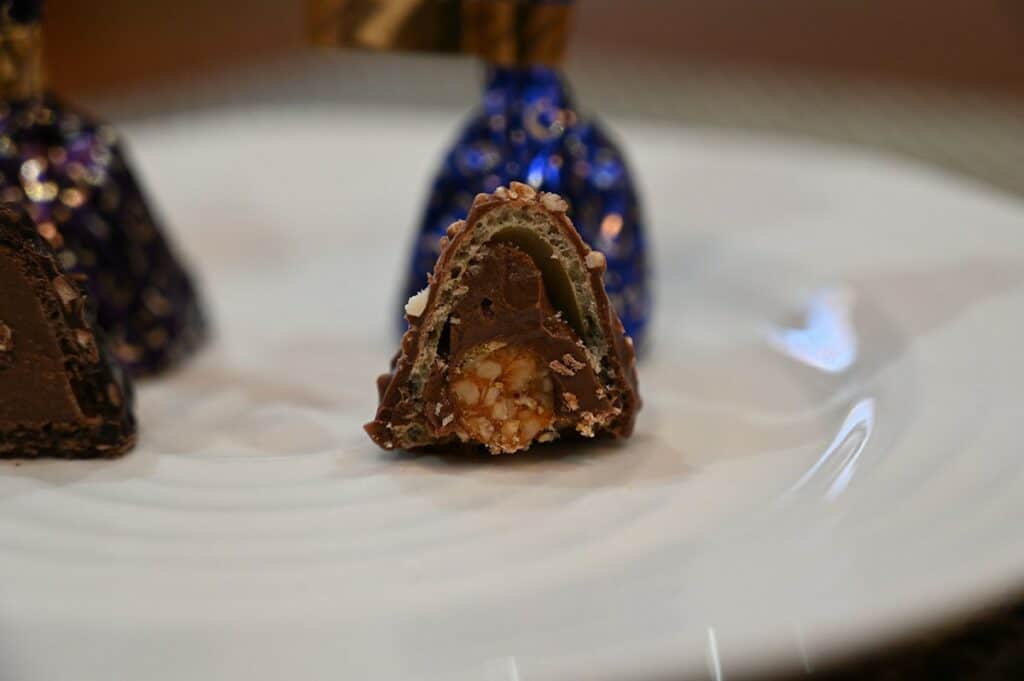 Closeup image of the Costco Godiva Milk Chocolate Hazelnut Dome with a bite taken out of it. 