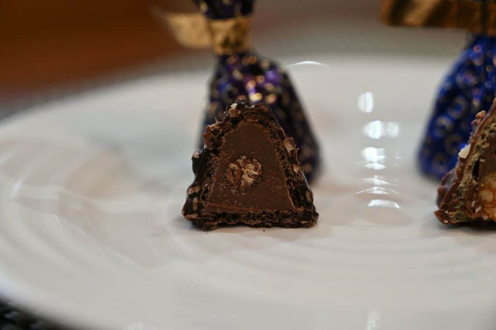 Closeup image of the Costco Godiva Dark Chocolate Hazelnut Dome with a bite taken out of it. 