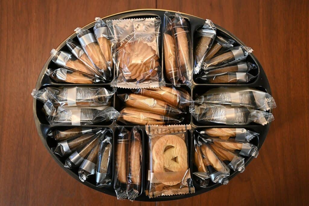 Top down image of the Costco Isabelle Assorted Cookie Tin with the lid off showing that the cookies come individually packaged in plastic. 