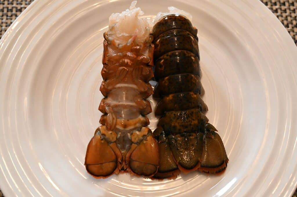 Side image of thawed Seacore Frozen Lobster Tails on a plate before cooking them. 