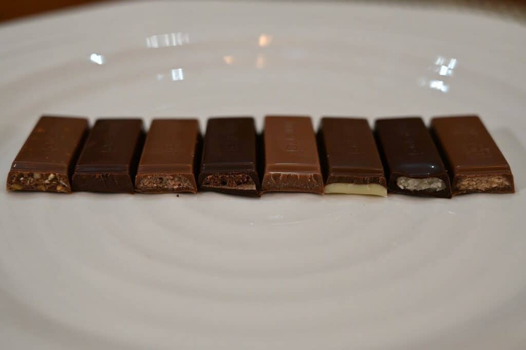 Image of the eight different varieties of Costco Merci European Chocolates unwrapped and on a plate with a bite taken out of each