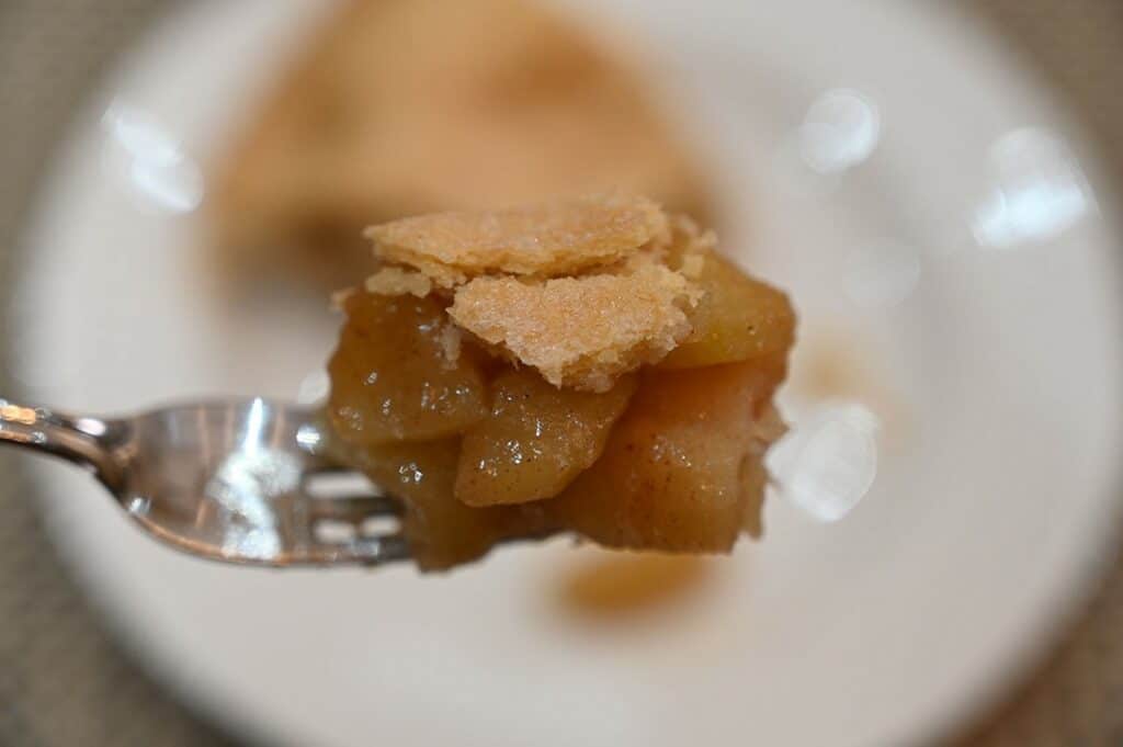 Closeup image of a bite of Costco homestyle apple pie on a fork. 