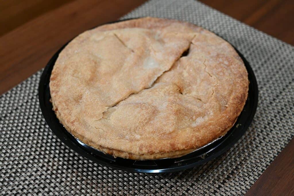 Costco Kirkland Signature Homestyle Apple Pie with the lid off on a placemat