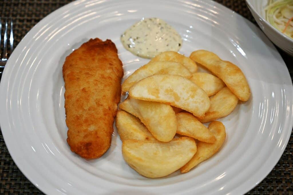 Costco Kirkland Signature Fish & Chips Meal Kit fish, chips and tartar sauce plated on a white plate. 
