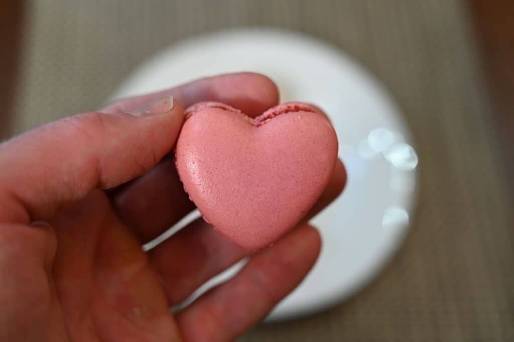 Closeup image of one raspberry Costco Le Bon Patisserie Heart Shaped Macaron. 