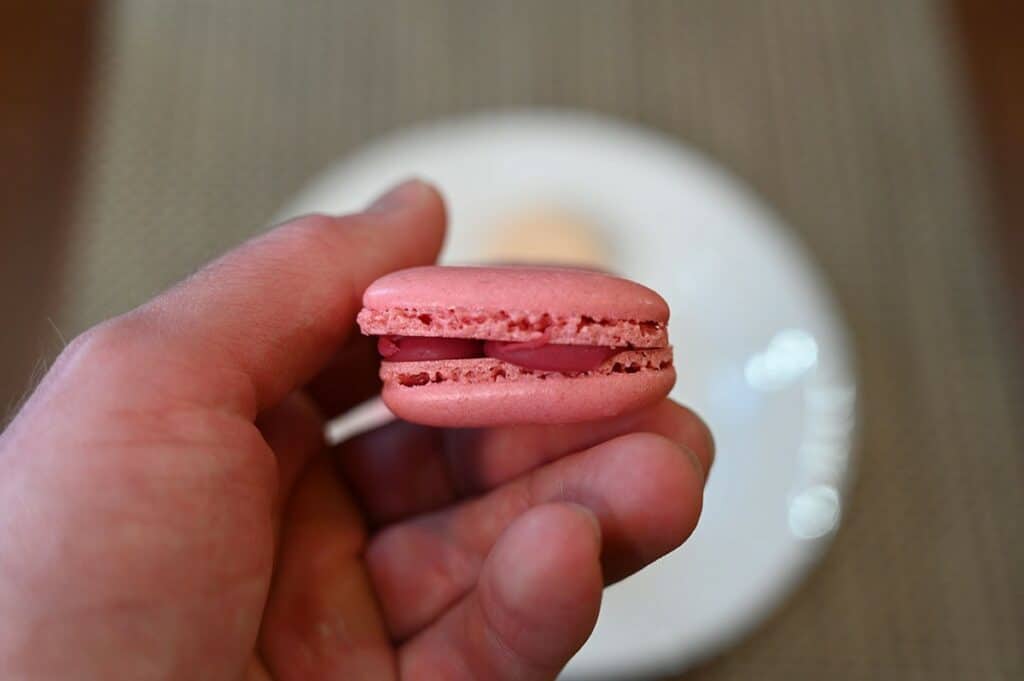 Closeup side view image so you can see the filling of the raspberry Costco Le Bon Patisserie Heart Shaped Macarons.