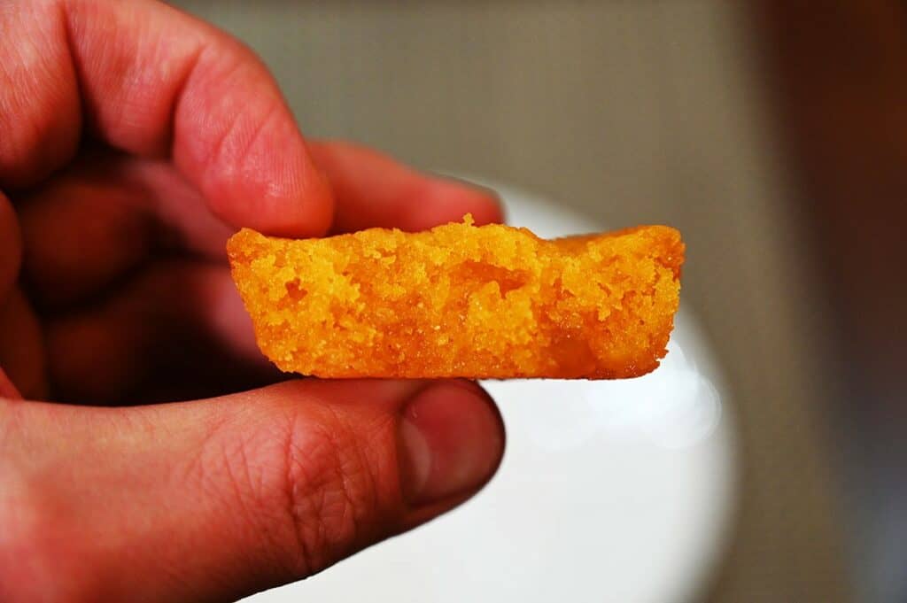 Closeup image of one Costco Sugar Bowl Bakery Mango Cake with a bite taken out so you can see the texture of the inside.