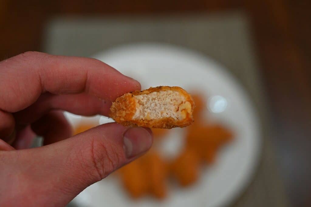 Closeup image of one Costco Pinty's Buffalo Chicken Fling with a bite taken out so you can see the middle. 