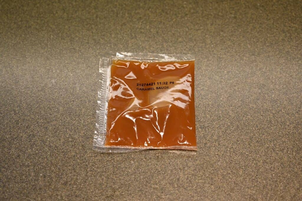 Costco Summ! Apple Pie Rolls caramel sauce packet sitting on counter. 