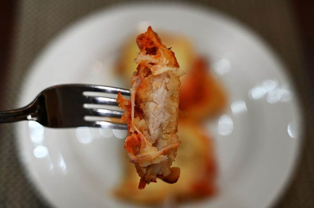 Closeup image of the chicken that comes in the Costco Kirkland Signature Chicken Parmigiana on Cheese Lasagna cooked and on a fork. 
