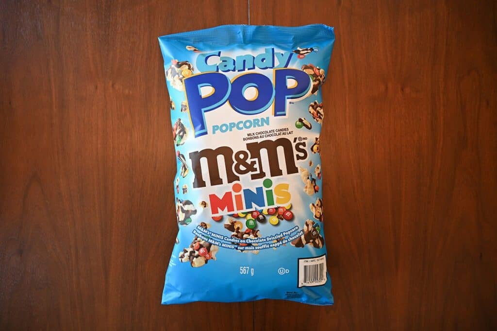 Costco Candy Pop Popcorn M&M's Minis bag sitting on a table, top down view. 