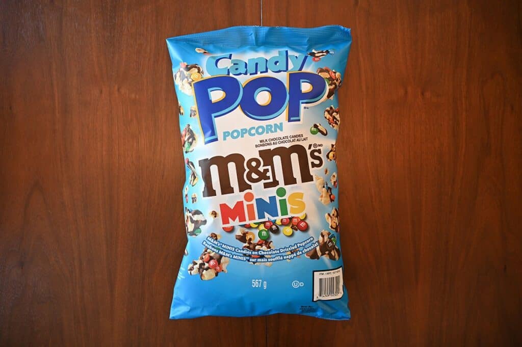 Costco Candy Pop Popcorn M&M's Minis bag sitting on a table, top down view. 