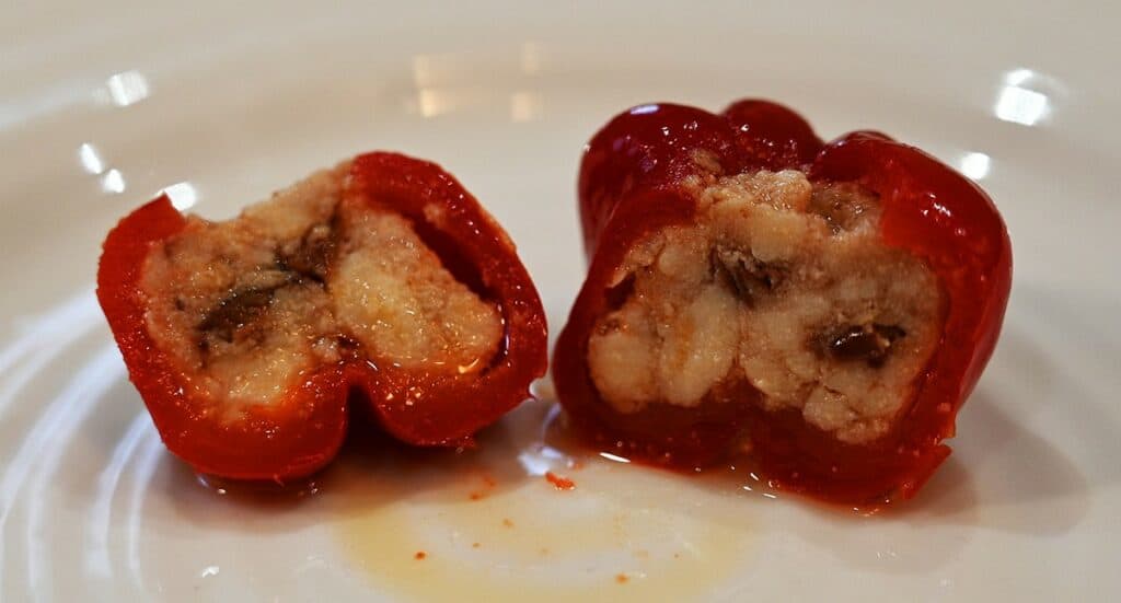 One Costco Tasso's Papandoro Peppers Stuffed With Feta & Kalamata Olives on a plate, cut in half, closeup image so you can see what's inside. 