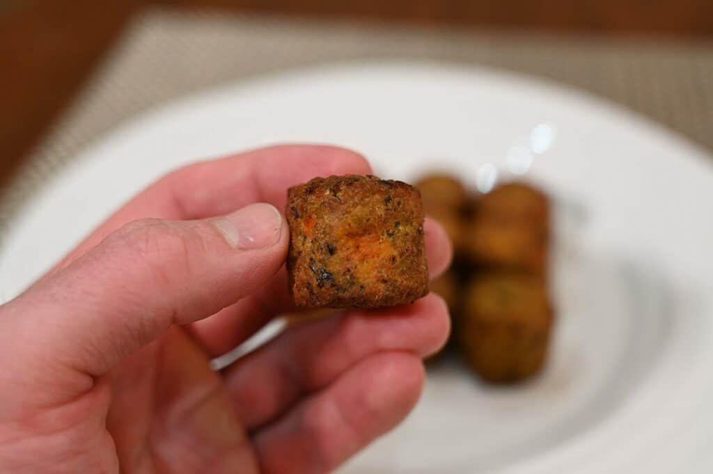 Close up image of one  Costco Don Lee Farms Organic Veggie Bite with more veggie bites on a white plate in the background