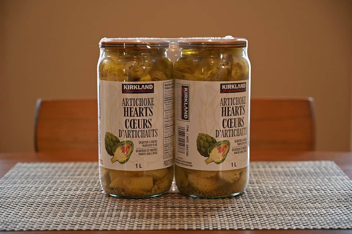 Image of the two-pack jars of artichoke hearts on a placement on a table. 