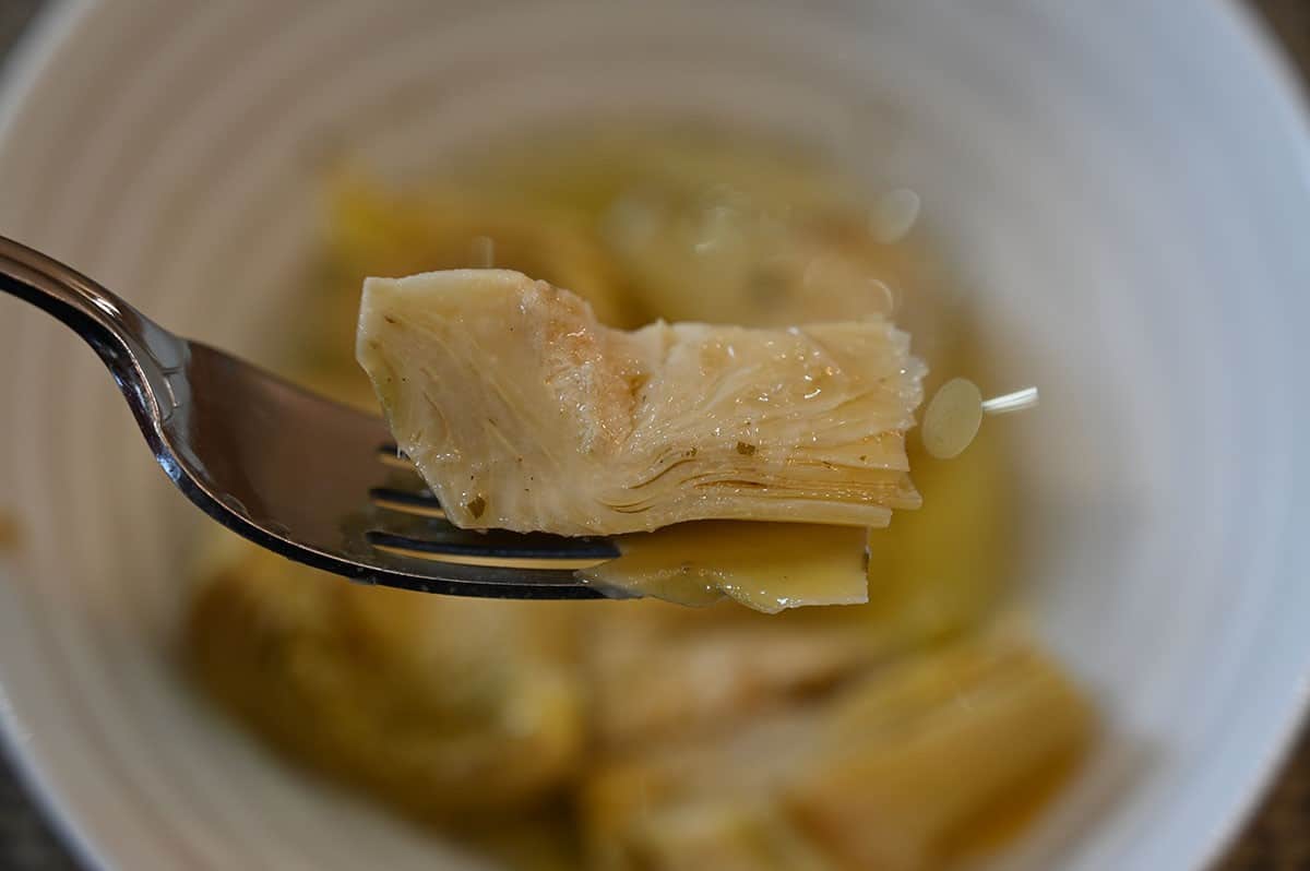 Close up image of one artichoke heart on a fork. 