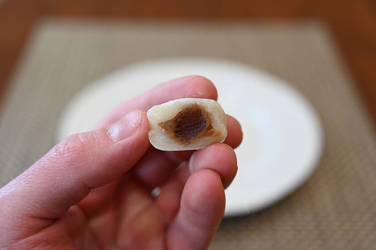 Closeup image of one Costco Tropical Fields Boba Milk Tea Mochi with a bite taken out of it so the middle is seen.