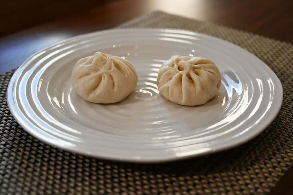 Costco Made Fresh Foods BBQ Pork Buns, two buns on a plate before heating. 