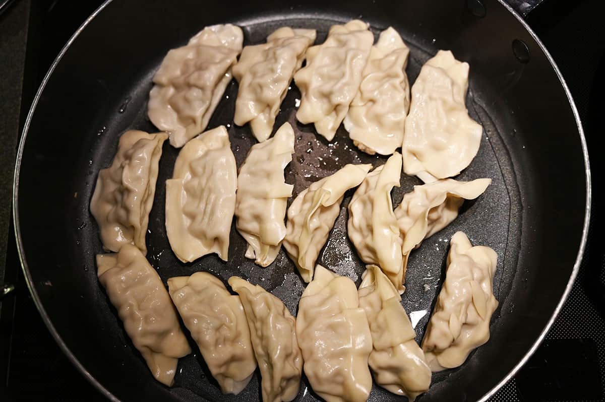 Costco Summ! Gyoza Dumplings in a fry pan cooking. Top down image. 