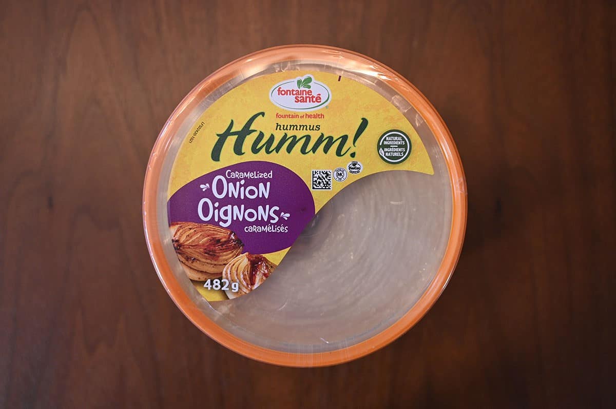 Top down image of Fontaine Santé Humm! Caramelized Onion Hummus sitting on a wood table.  