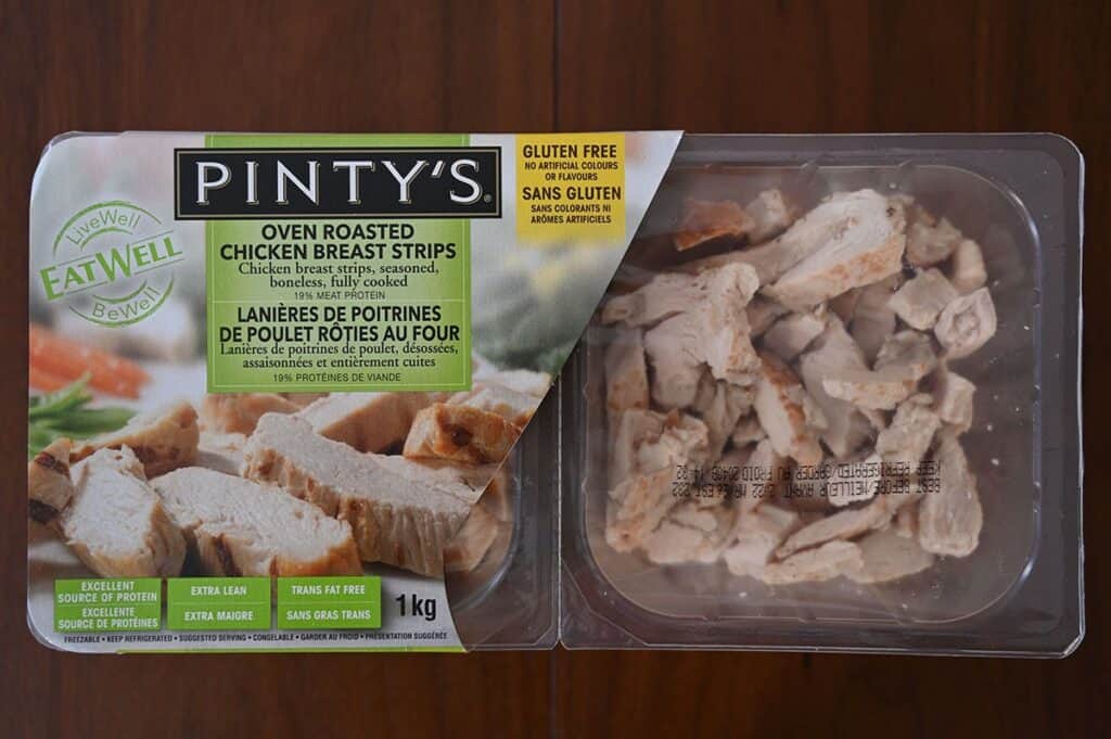 Costco Pinty's Oven Roasted Chicken Breast Strips package sitting on a wood table.